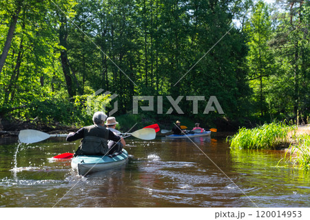 Group kayak trip for seigneur and senora . An elderly couple And adult rowing boat on the river, a water hike, a summer adventure. Age-related sports, mental youth and health, tourism, active old age 120014953