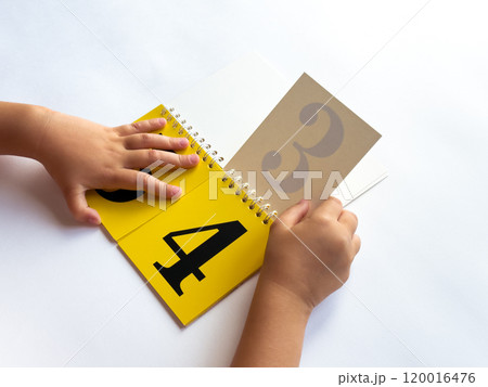 Child learning numbers with a colorful educational flip book 120016476