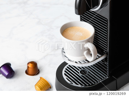 Cup of fresh morning coffee from home coffee machine with espresso pod on white background. 120019269