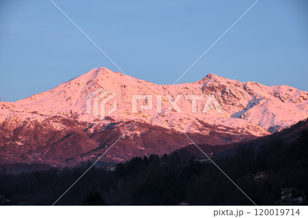 profile of a Piedmont alp overlooks the Po Valley immersed in a pink sunset 120019714
