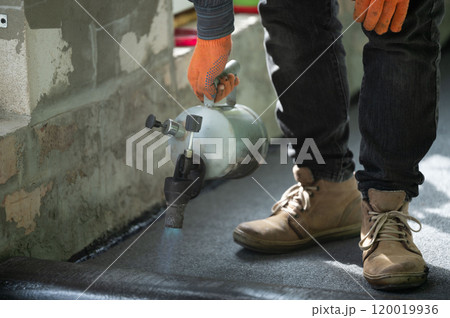 Repair work inside the house, waterproofing the floor, a man with a kerosene lamp. Repair work inside the house, waterproofing the floor, a man with a kerosene lamp. 120019936
