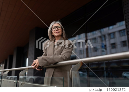 Middle-aged Caucasian businesswoman outdoors on a balcony reflecting on her professional journey Middle-aged Caucasian businesswoman outdoors on a balcony reflecting on her professional journey 120021272