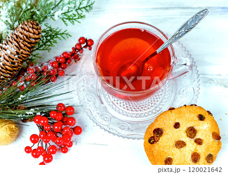Christmas tea in glass Cup . composition with cookie, pine branches, cones on background of garlands on wooden table Christmas tea in glass Cup . composition with cookie, pine branches, cones on background of garlands on wooden table 120021642