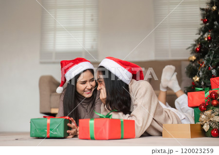 Joyful Lesbian Couple Celebrating Christmas Together with Gifts and Festive Cheer in a Cozy Home Setting Joyful Lesbian Couple Celebrating Christmas Together with Gifts and Festive Cheer in a Cozy Home Setting 120023259