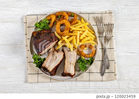 Baked pork ribs with onion rings and french fries 120023459