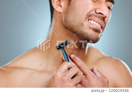 Frustrated man, hands and shaving neck with razor blade for grooming, skincare or irritation on a blue studio background. Closeup, male person or young model with tool for hair removal in discomfort 120024588
