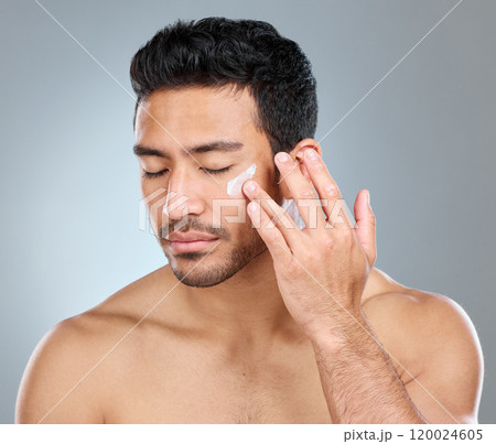 Man, eyes closed and cream in studio for skincare, hydration and skin tone with dermatology or cosmetology. Male person, lotion and sunscreen on gray background for facial care, grooming and calm. 120024605