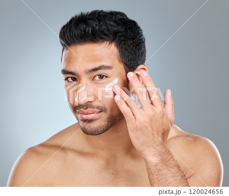 Man, happy and portrait with cream in studio for skincare, hydration and skin tone with dermatology or cosmetology. Person, lotion and sunscreen on gray background for facial care, grooming and glow. 120024656