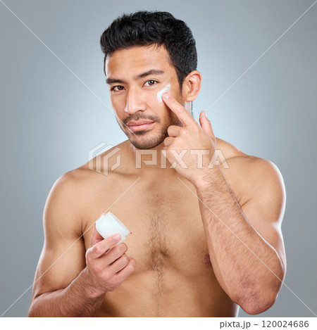 Man, jar and portrait with cream in studio for skincare, hydration and skin tone with dermatology or cosmetology. Person, lotion and sunscreen on gray background for facial care, grooming and glow. 120024686