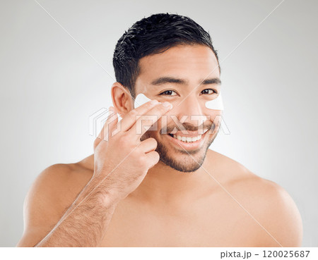 Portrait, man and cosmetic patches for grooming, anti aging and confidence with dermatology on white background. Male person, collagen and skincare for eyes in studio backdrop for wellness or glow 120025687