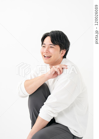 カジュアル　男性　笑顔　立て膝 120026089