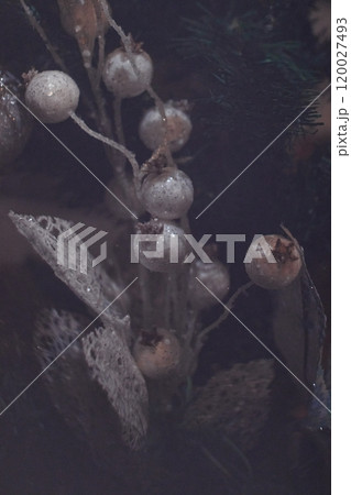 Christmas tree decorated with silver ornaments and white berries creating festive atmosphere. New Year 2025 120027493