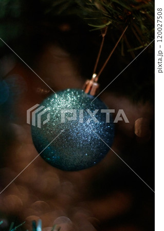 Transformative teal christmas ornament hanging from a christmas tree branch. New Year 2025 120027508