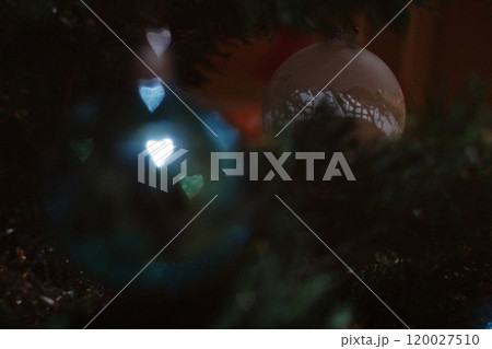 Christmas bauble hanging from christmas tree branch with blurry background. New Year 2025 Hearts bokeh 120027510