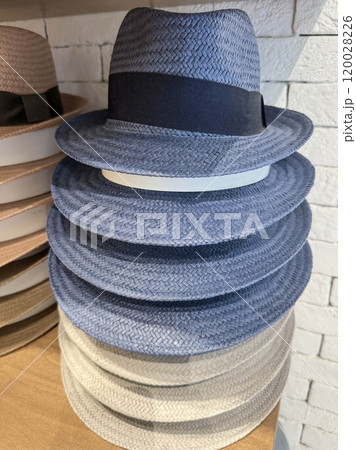 stack of blue straw hats in shop 120028226