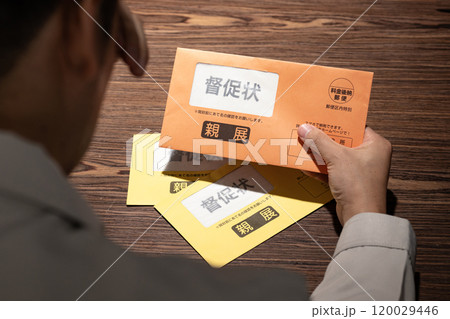 督促状を見て困る男性 120029446