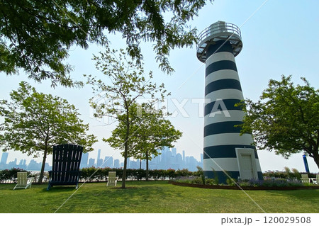 Green lawn of the park with a decorative lighthouse 120029508
