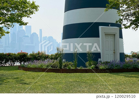 Green lawn of the park with a decorative lighthouse 120029510