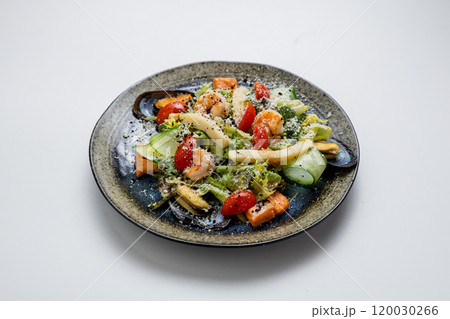 Gourmet seafood salad with mussels, shrimp, avocado, and cherry tomatoes, topped with grated cheese Gourmet seafood salad with mussels, shrimp, avocado, and cherry tomatoes, topped with grated cheese 120030266