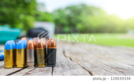 Various types of bullets displayed on a wooden surface, symbolizing the theme of firearm safety, the impact of violence, and the importance of responsible use and control of firearms. Various types of bullets displayed on a wooden surface, symbolizing the theme of firearm safety, the impact of violence, and the importance of responsible use and control of firearms. 120030336
