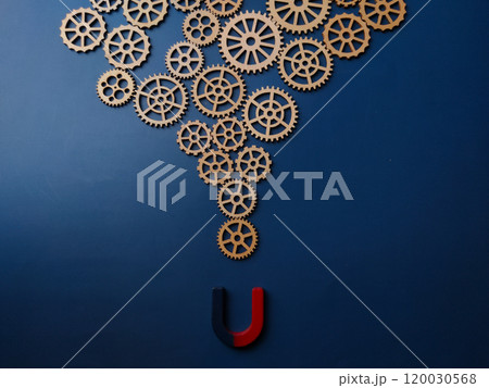 Magnet and wooden gear on a blue background. Magnet and wooden gear on a blue background. 120030568
