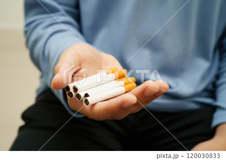 Asian man holding cigarette, no smoking. 120030833