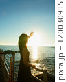 海辺で陽の光を浴びる女性 120030915