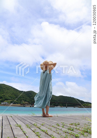 綺麗な海辺で空を見上げる女性 120030985