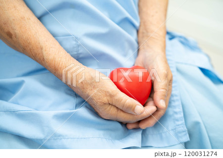 Asian elder senior woman patient holding red heart in hospital. 120031274
