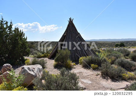 Hut of branches against the backdrop of a desert landscape 120032295