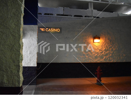 White wall of underground parking with illuminated casino sign. 120032341