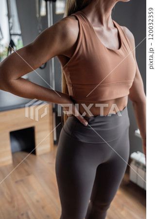 Pilates fitness trainer beautiful hand and shoulders relief. Pilates studio. Young sporty attractive woman wearing sportswear in yoga studio. Fit, healthy and strong authentical body. Fitness concept 120032359