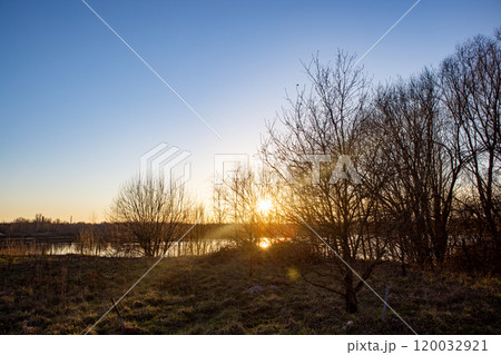 A Serene and Beautiful Sunset Over Calm and Tranquil Waters, Surrounded by Lush Trees 120032921