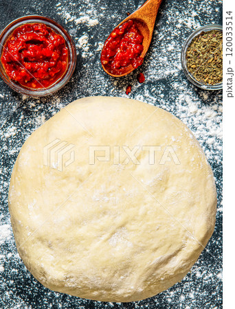 Raw dough preparation or pizza with ingredient: tomato sauce, spices. Flat lay style. Raw dough preparation or pizza with ingredient: tomato sauce, spices. Flat lay style. 120033514