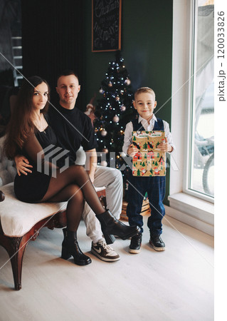 Happy family mom dad son at the Christmas tree on Happy family mom dad son at the Christmas tree on 120033826