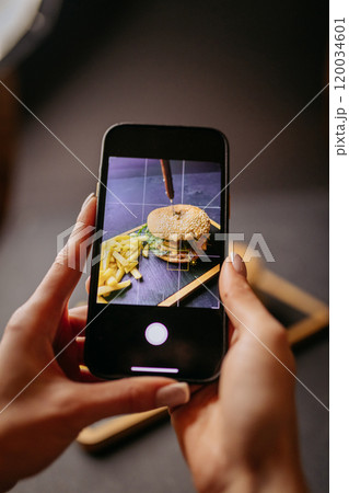 Capturing a gourmet burger and fries with a smartphone, a food photography moment Capturing a gourmet burger and fries with a smartphone, a food photography moment 120034601