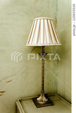 Decorative vintage lamp on top of a table with the light on Decorative vintage lamp on top of a table with the light on 120035026