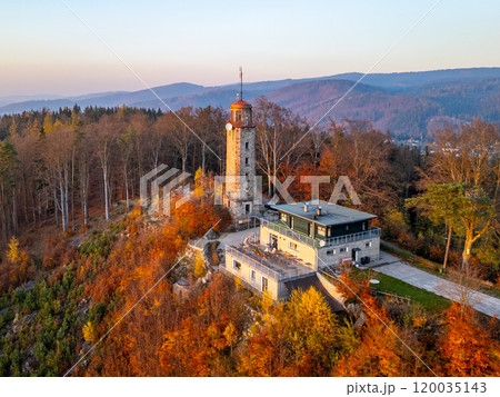 The lookout tower on Prosec Ridge stands majestically during an autumn sunset, surrounded by colorful foliage in the Jizera Mountains near Jablonec nad Nisou, Czechia. The lookout tower on Prosec Ridge stands majestically during an autumn sunset, surrounded by colorful foliage in the Jizera Mountains near Jablonec nad Nisou, Czechia. 120035143