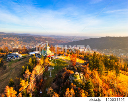 The Tanvaldsky Spicak Lookout Tower stands majestically as autumn foliage blankets the landscape in vibrant hues, capturing the beauty of an evening in the Jizera Mountains. The Tanvaldsky Spicak Lookout Tower stands majestically as autumn foliage blankets the landscape in vibrant hues, capturing the beauty of an evening in the Jizera Mountains. 120035595
