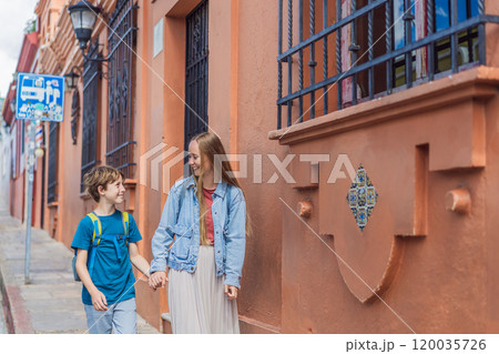 Mother and her son tourists walks through the colonial streets San Cristobal de las Casas, Mexico. Cultural exploration, architecture, and travel experience concept 120035726