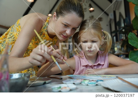 A young mother and her daughter enjoy a creative art session at home  120037197