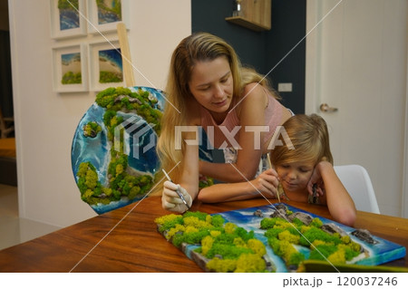 A mother and her daughter craft vibrant natural landscapes  120037246
