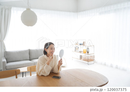 鏡で口元のチェックをする女性 120037375
