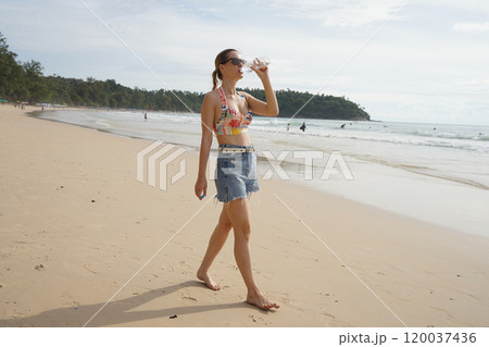A young woman enjoying a beautiful day at the beach  120037436