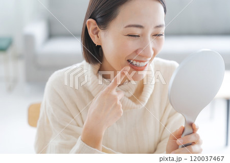 鏡で口元のチェックをする女性 120037467