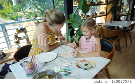 A young mother and her daughter enjoy a creative art session at home  120037578