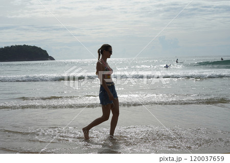 A young woman enjoying a beautiful day at the beach  120037659