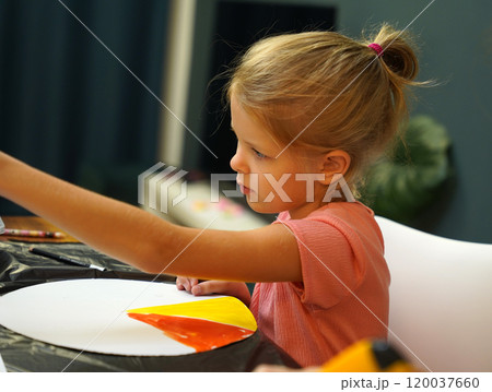 A mother and her young daughter engage in a colorful painting activity  120037660
