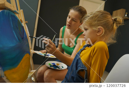 Teacher in workshop teched two girls how to assemble a thermo mosaic  120037726