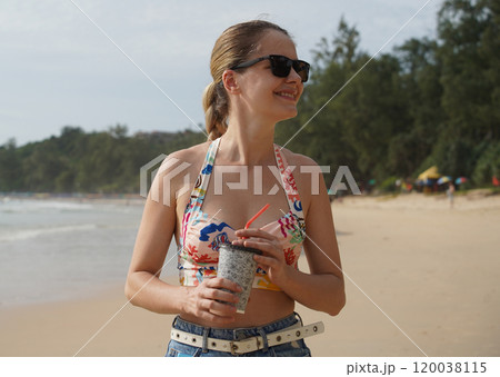 A young woman enjoying a beautiful day at the beach A young woman enjoying a beautiful day at the beach 120038115